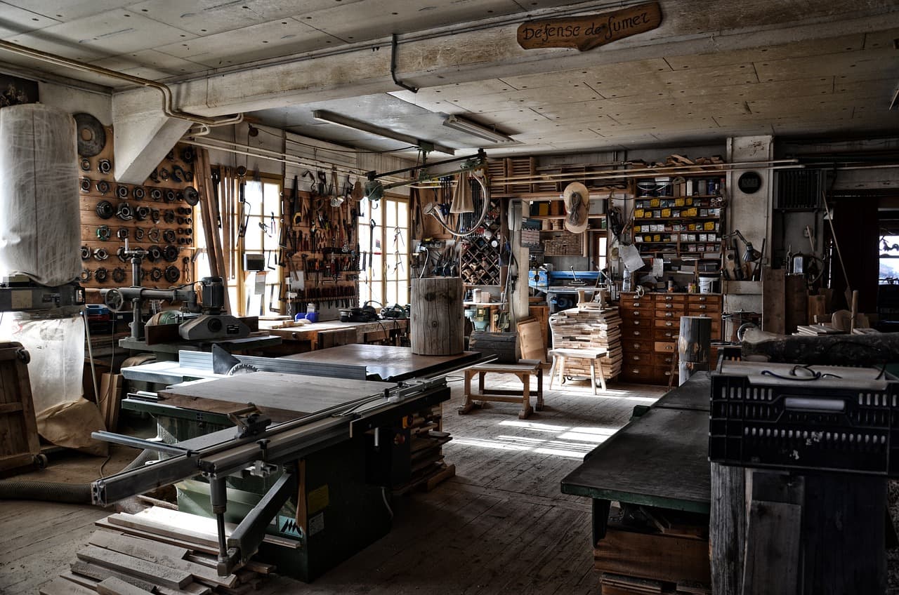 Atelier de menuiserie avec ses établis, ses machines et ses outils rangés au mur